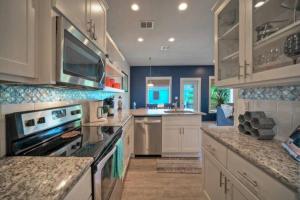 a large kitchen with white cabinets and a stove top oven at Rock N Reel by AvantStay Old Town Location in Port Aransas