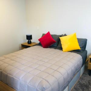 una cama con almohadas coloridas encima en Christchurch Airport Stop en Christchurch