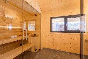 una sauna con paredes de madera y una ventana en Kreischberg Pool Villas & Penthouses by ALPS RESORTS en Sankt Lorenzen ob Murau