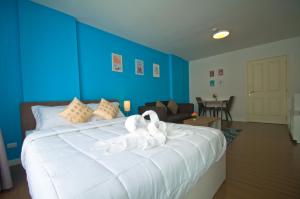 a bedroom with a large white bed with blue walls at Baan Im Em by little dragon in Hua Hin