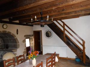 uma sala de jantar com uma mesa e uma escada em Gîte de France à Saint-Martin-la-Méanne 2 épis - Gîte de France 5 perso 854 em Saint-Bazile-de-la-Roche