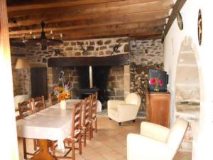 uma sala de jantar com uma mesa e cadeiras e uma lareira em Gîte de France à Saint-Martin-la-Méanne 2 épis - Gîte de France 5 perso 854 em Saint-Bazile-de-la-Roche