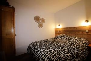 a bedroom with a black and white comforter on a bed at Quartier La Forêt - maeva Home - Appartement 3 pièces 6 personnes Sélection MAE-5126 in Valmorel