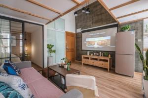 ein Wohnzimmer mit einem Sofa und einem Flachbild-TV in der Unterkunft Shanghai Hills&XING 1883 Homestay in Shanghai