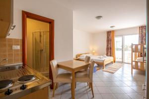 a kitchen and dining room with a table and a sink at Apartments Eddy Veselica in Novalja