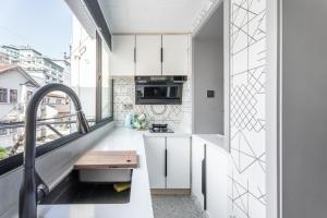a kitchen with white cabinets and a large window at Shanghai Hills&XING 1884 Family Homestay Near Line2 & Line12 West Nanjing Road in Shanghai +13 photos