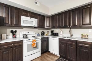 a kitchen with white appliances and wooden cabinets at Univ City Drexel 3 Bdrm Lovely Unit in Philadelphia