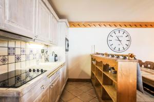 uma cozinha com um grande relógio na parede em Résidence Les Alpages de Reberty - maeva Home - Appartement 3 pièces 6 pers 26 em Les Menuires