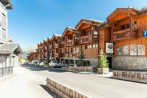 a row of wooden buildings on a street at Résidence Les Chalets du Forum - maeva Home - Appartement 2 pièces 6 person 30 in Courchevel