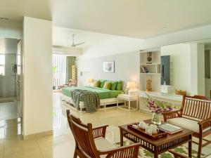 uma sala de estar com uma cama verde e uma mesa em Kidena House em Goa Velha