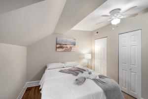 a white bedroom with a bed with a ceiling fan at Univ City Drexel 3 Bdrm Lovely Unit in Philadelphia