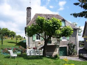 a house with a tree and a table and chairs at Gîte de France à Allassac 3 épis - Gîte de France 4 personnes MAE-9994 in Allassac