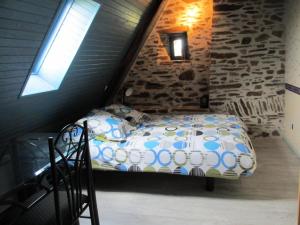 ein Schlafzimmer mit einem Bett auf einem Dachboden in der Unterkunft Gîte de France Gite de la genette 3 épis - Gîte de France 8 personnes MAE-0024 in Beyssenac