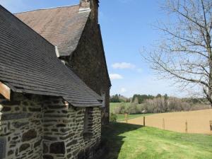 ein altes Steingebäude mit einem Feld im Hintergrund in der Unterkunft Gîte de France Gite de la genette 3 épis - Gîte de France 8 personnes MAE-0024 in Beyssenac