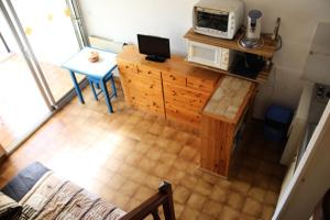 an overhead view of a kitchen with a microwave on a counter at Résidence HELIOVILLAGE - Maisons & Villas pour 4 Personnes 664 - Naturiste in Cap d'Agde