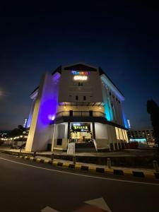 淡马鲁Hotel Apsara Temerloh Gateway的夜晚街道边的一栋建筑