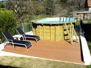a deck with a pool with chairs and a swing at Gîte de France La maison de louise 3 épis - Gîte de France 4 personnes MAE-0014 in La Bitarelle
