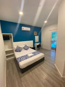 a bedroom with a bed and a blue wall at Hotel Apsara Temerloh Gateway in Temerloh