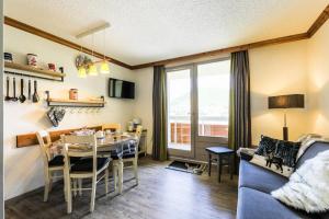 a dining room and living room with a table and a couch at Résidence Les Bergers - maeva Home - Studio 4 personnes - Sélection MAE-6894 in LʼHuez