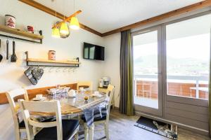 a dining room with a table and chairs and a window at Résidence Les Bergers - maeva Home - Studio 4 personnes - Sélection MAE-6894 in LʼHuez