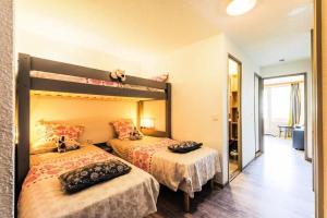 a bedroom with two beds and a mirror at Résidence Les Bergers - maeva Home - Studio 4 personnes - Sélection MAE-6894 in LʼHuez +25 photos