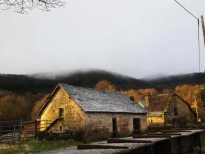 an old stone barn with a mountain in the background at Gîte de France Des alpagas épis - Gîte de France 944 in Chaumeil