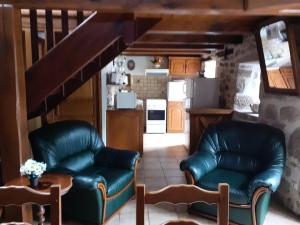 a living room with two leather chairs and a kitchen at Gîte de France à Saint-Cirgues-la-Loutre 3 épis - Gîte de France 2 personnes MAE-0054 in Saint-Cirgues-la-Loutre