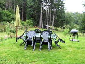 two chairs and a table and a grill in the grass at Gîte de France La barthèçoice 3 épis - Gîte de France 7 personnes MAE-0074 in Tarnac