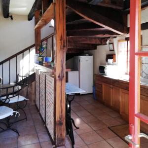 eine Küche mit einem Tisch und einem Kühlschrank in der Unterkunft Gîte de France à Curemonte 3 épis - Gîte de France 6 personnes 034 in Curemonte