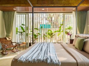 ein großes Bett in einem Zimmer mit einem großen Fenster in der Unterkunft Kidena House in Goa Velha