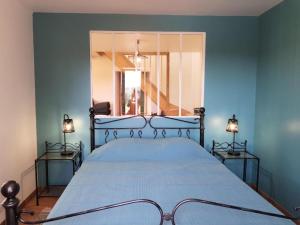 Schlafzimmer mit einem Bett mit blauen Wänden und einem Fenster in der Unterkunft Gîte de France Gîte bel air 3 épis - Gîte de France 6 personnes 124 