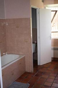 uma casa de banho com banheira e piso em azulejo em Gîte de France à Alleyrat 3 épis - Gîte de France 6 personnes 094 em Alleyrat