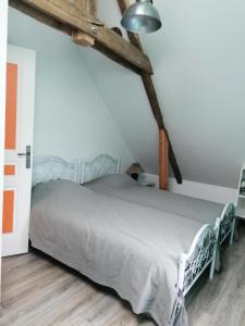 Schlafzimmer mit einem weißen Bett und Holzboden in der Unterkunft Gîte de France Gîte bel air 3 épis - Gîte de France 6 personnes 124 