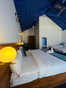 a bedroom with a large white bed with a blue ceiling at Shree Kalya Resort- Chikmagalur in Chikmagalūr