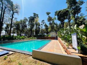 a swimming pool in a yard with a sign next to it at Shree Kalya Resort- Chikmagalur in Chikmagalūr