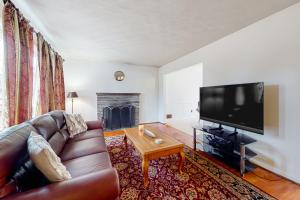 een woonkamer met een bank en een flatscreen-tv bij Upstate Memories in Rochester