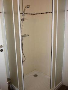 a shower with a glass door in a bathroom at Gîte de France à Vars-sur-Roseix 3 épis - Gîte de France 9 personnes MAE-0184 in Vars-sur-Roseix +12 photos