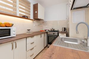 una cucina con lavandino e forno a microonde di Apartment with 2 Bedroom & Balcony Gdańsk Near The Old Town by Renters a Danzica