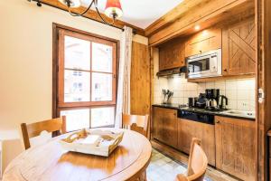 - une cuisine avec une table en bois dans une chambre dans l'établissement Résidence Les Arcs Le Village - maeva Home - Appartement pièces Sélection 64, à Bourg-Saint-Maurice