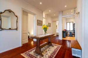 a room with a table with a vase of flowers on it at Palazzo Boito Luxury Apartment on Lido with Venice view in Venice-Lido