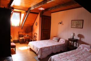 a bedroom with two beds and a table and chairs at Gîte de France à Toy-Viam 3 épis - Gîte de France 4 personnes MAE-0254 in Tarnac