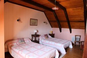 a bedroom with two beds and a wooden ceiling at Gîte de France à Toy-Viam 3 épis - Gîte de France 4 personnes MAE-0254 in Tarnac