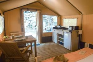 a kitchen and dining room with a table and a stove at Delfino Tuscany Resort in Marina di Cecina