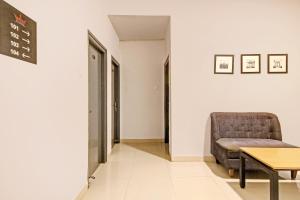 a waiting room with a chair and a table at OYO Townhouse 572 SS SKYLINE in Shamshabad