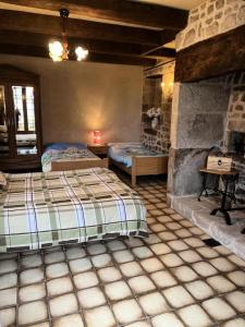 1 Schlafzimmer mit 2 Betten und einem Kamin in der Unterkunft Gîte de France La bachellerie 2 épis - Gîte de France 5 personnes 264 