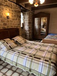 ein Schlafzimmer mit einem Bett in einer Steinmauer in der Unterkunft Gîte de France La bachellerie 2 épis - Gîte de France 5 personnes 264 