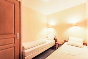 a small room with two beds and a door at Résidence Les Valmonts - maeva Home - Appartement 3 pièces 6 personnes Sélection MAE-7194 in Saint-Martin-de-Belleville