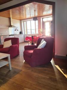 ein Wohnzimmer mit einem roten Sofa und einem Tisch in der Unterkunft Gîte de France Les embruns 3 épis - Gîte de France 6 personnes 284 in Altillac