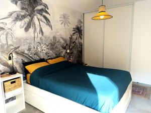 een slaapkamer met een groot bed met een palmmuurschildering bij - Pièces 934 in Aix-les-Bains