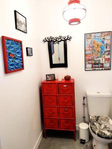 een badkamer met een rode dressoir en een toilet bij - Pièces 934 in Aix-les-Bains